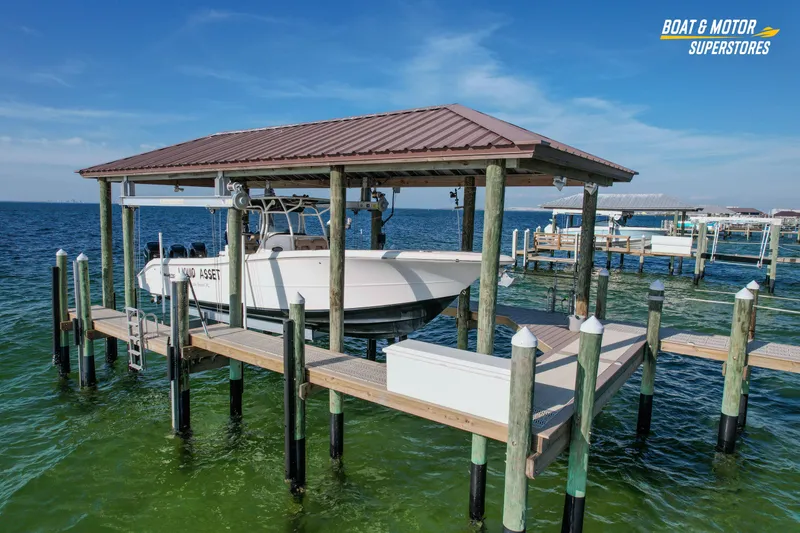 Slide: The Image of 2018 Key West Billistic 351 Center Console boat docked on a lift over clear water. - 32