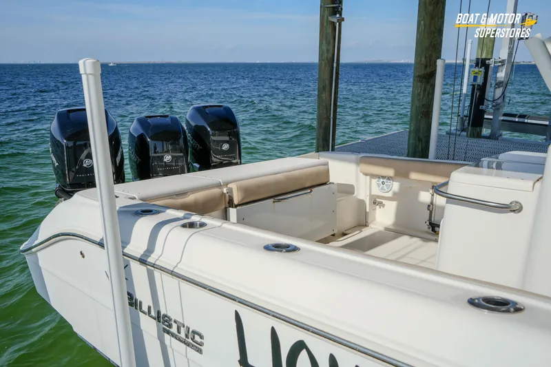 Slide: The Image of 2018 Key West Billistic 351 Center Console boat with triple outboard engines docked by the sea. - 53