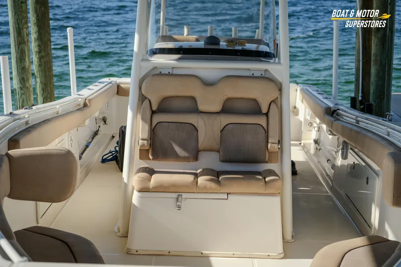 Slide: The Image of 2018 Key West Billistic 351 Center Console interior with seating, docked by the water. - 66