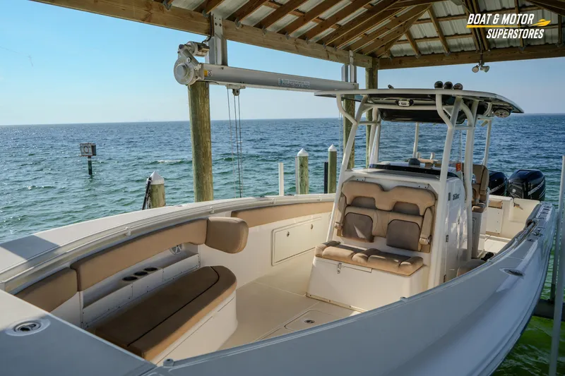 Slide: The Image of 2018 Key West Billistic 351 Center Console boat docked by the ocean under a wooden canopy. - 69