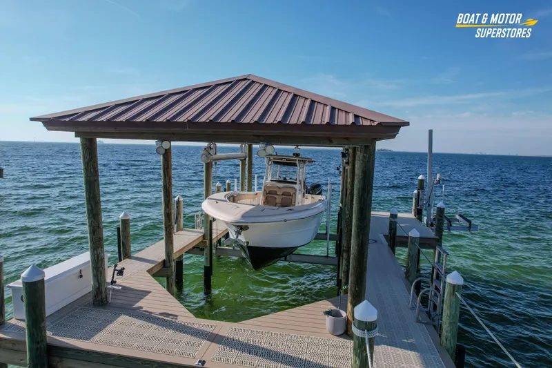 Slide: The Image of 2018 Key West Billistic 351 Center Console boat docked on a lift by the ocean. - 7