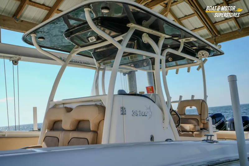 Slide: The Image of 2018 Key West Billistic 351 Center Console boat under a dock, featuring comfortable seating. - 73