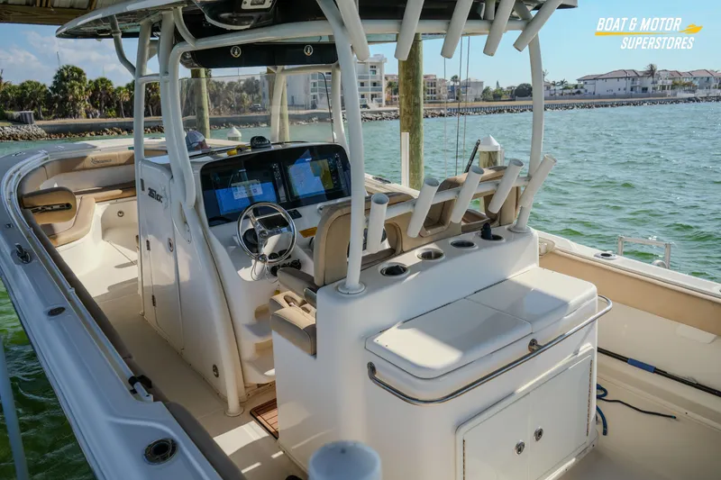 Slide: The Image of 2018 Key West Billistic 351 Center Console boat interior with helm and seating, docked by the water. - 88