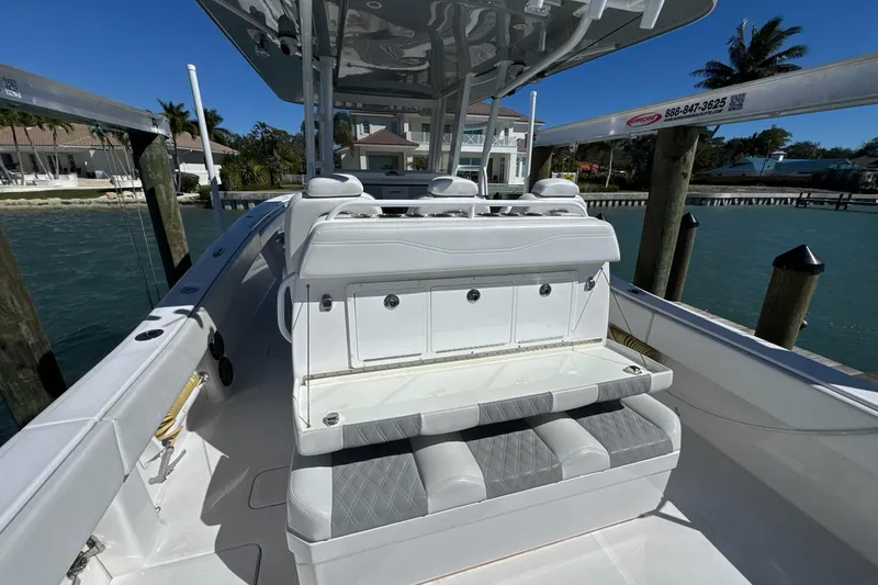 Slide: The Image of 2019 Invincible 39 Open Fisherman boat interior with seating and storage, docked by waterfront homes. - 14