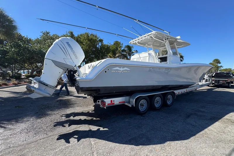 Slide: The Image of 2019 Invincible 39 Open Fisherman boat on trailer, parked outdoors under clear blue sky. - 32