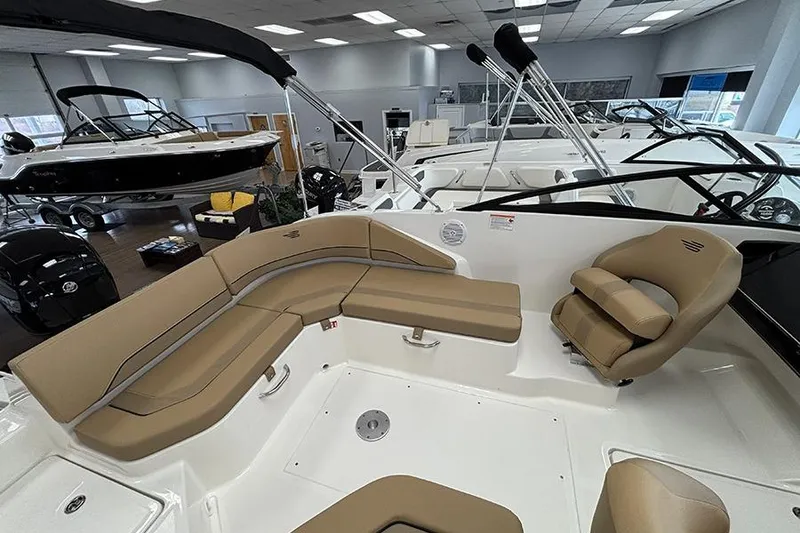 Slide: The Image of 2026 Bayliner V20 boat interior with beige seating in showroom. - 10