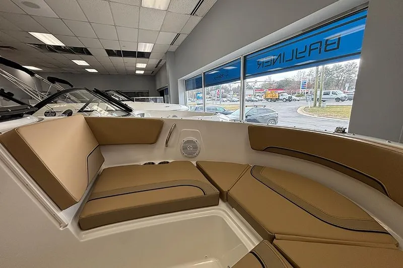 Slide: The Image of 2026 Bayliner V20 boat interior with tan seating in showroom. - 21