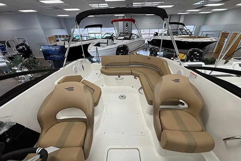 Slide: The Image of 2026 Bayliner V20 boat interior with beige seating in showroom. - 7