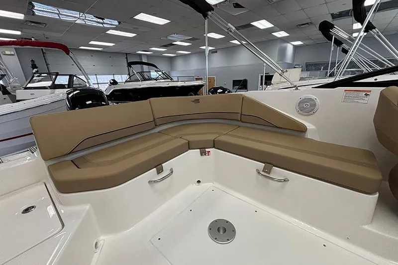 Slide: The Image of 2026 Bayliner V20 boat interior with tan seating in showroom. - 8