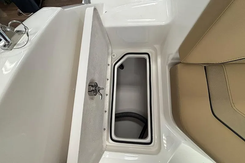 Slide: The Image of 2026 Bayliner V20 boat storage compartment with beige seating and white interior. - 9