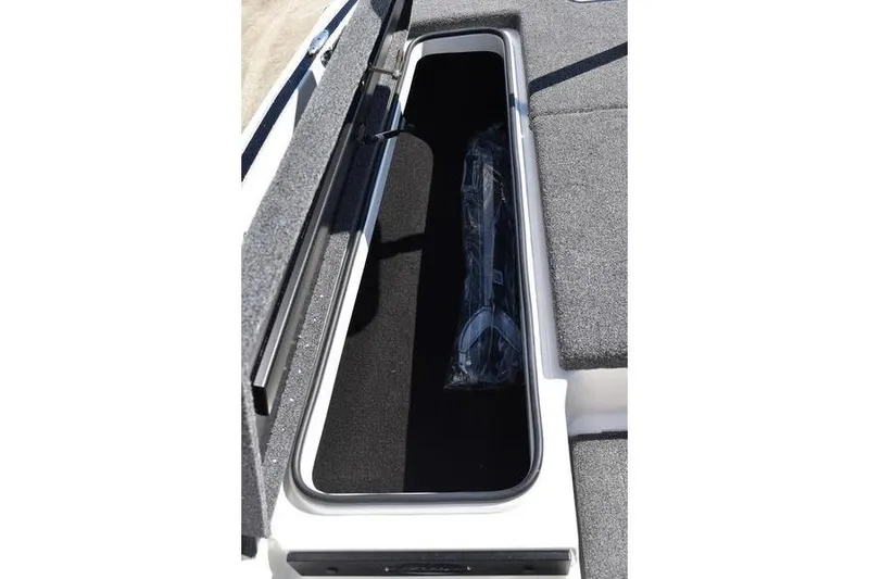 Slide: The Image of Open storage compartment in 2026 Lowe Skorpion SS boat, featuring carpeted interior. - 20