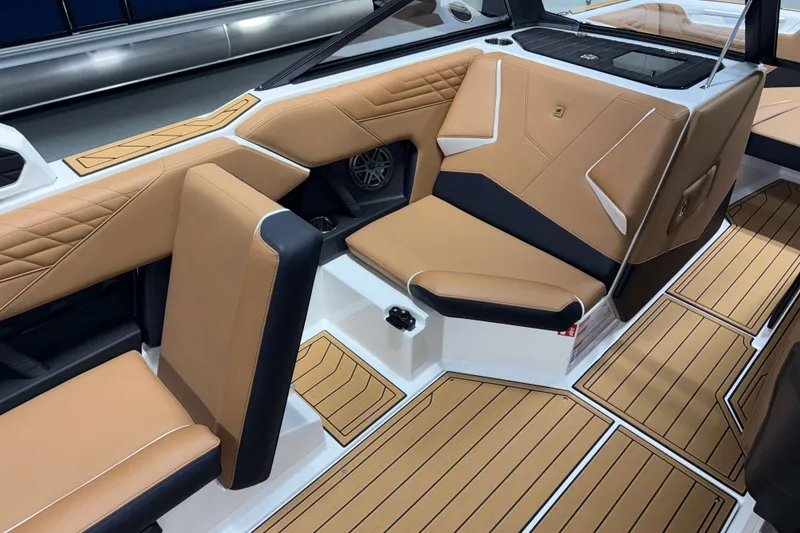 Slide: The Image of 2026 Nautique Super Air Nautique S23 interior with tan and black seating, stylish design. - 12