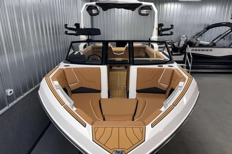 Slide: The Image of 2026 Nautique Super Air Nautique S23 boat with luxurious tan seating in a showroom. - 2