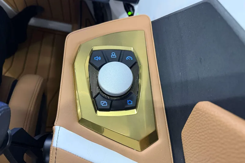 Slide: The Image of Control panel of 2026 Nautique Super Air Nautique S23 boat with gold accents. - 21