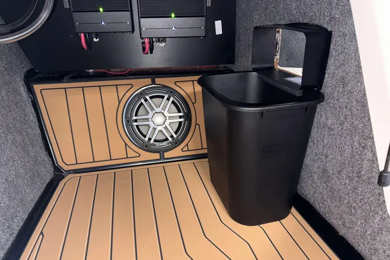 Slide: The Image of Interior of 2026 Nautique Super Air Nautique S23 with speaker and storage bin. - 24