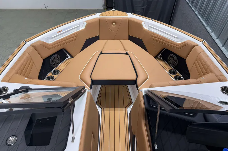 Slide: The Image of 2026 Nautique Super Air Nautique S23 boat interior with tan leather seating and cup holders. - 27