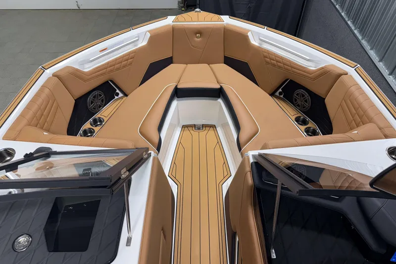 Slide: The Image of 2026 Nautique Super Air Nautique S23 boat interior with tan leather seating and cup holders. - 28