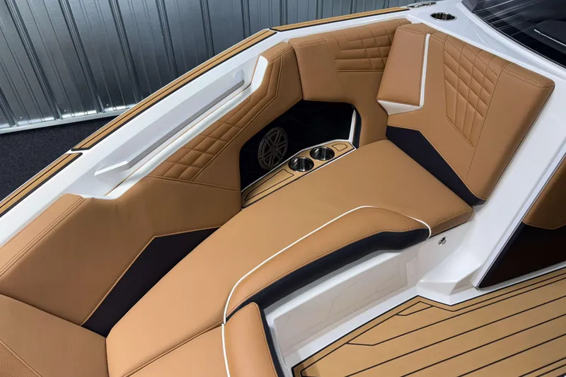 Slide: The Image of 2026 Nautique Super Air Nautique S23 interior with tan leather seating and cup holders. - 30