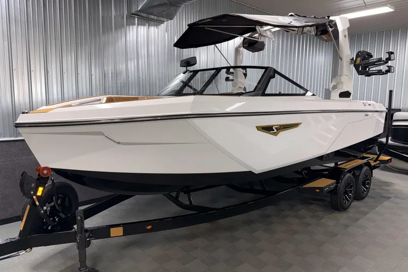 Slide: The Image of 2026 Nautique Super Air Nautique S23 boat in showroom, sleek design, on trailer. - 36