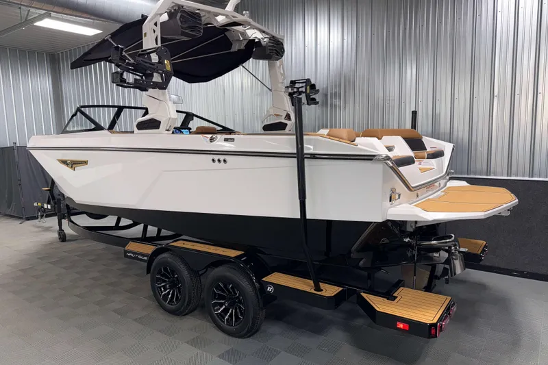 Slide: The Image of 2026 Nautique Super Air Nautique S23 boat in a showroom, side and rear view. - 39
