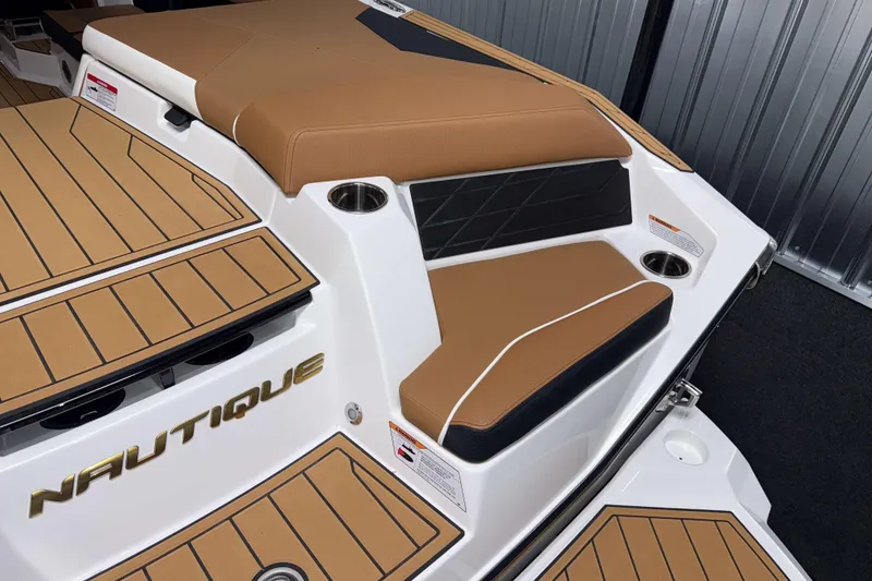 Slide: The Image of 2026 Nautique Super Air Nautique S23 boat interior with tan seating and cup holders. - 4