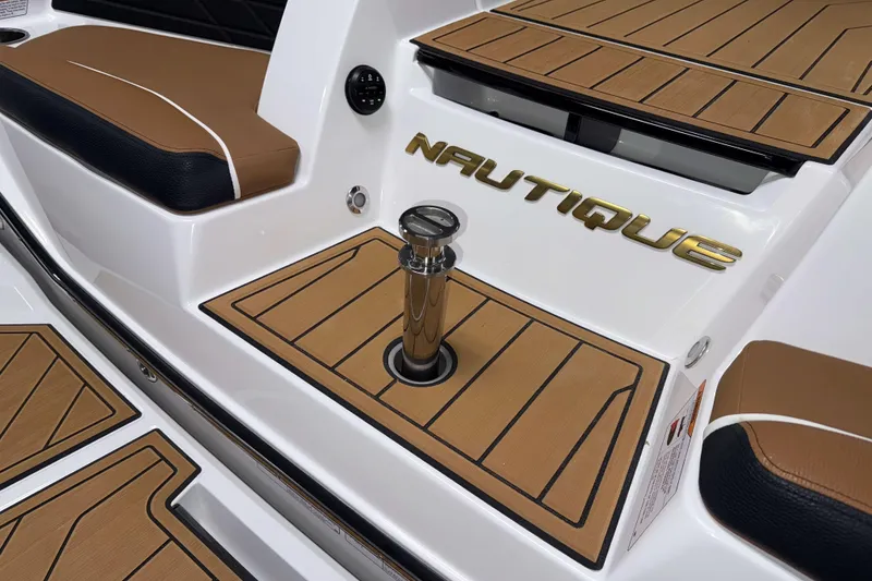 Slide: The Image of 2026 Nautique Super Air Nautique S23 boat interior with teak flooring and branded detailing. - 6