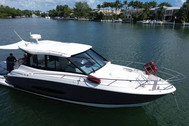 Slide: The Image of 2021 Regal 36 XO boat docked, reflecting on calm green water. - 33