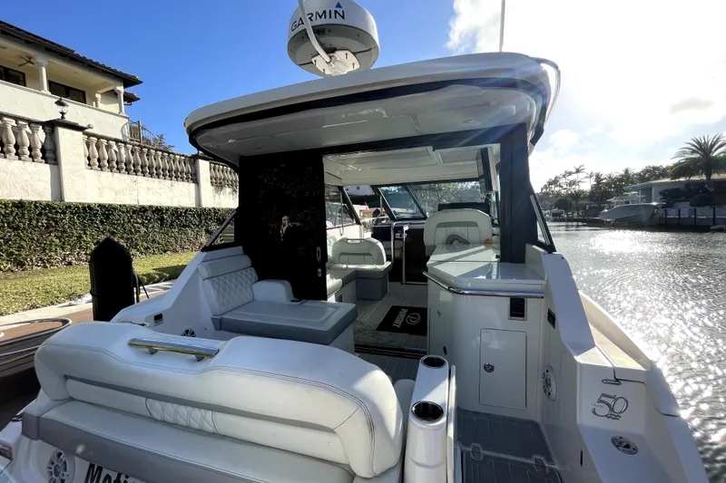 Slide: The Image of 2021 Regal 36 XO luxury yacht interior with seating, docked by waterfront. - 38