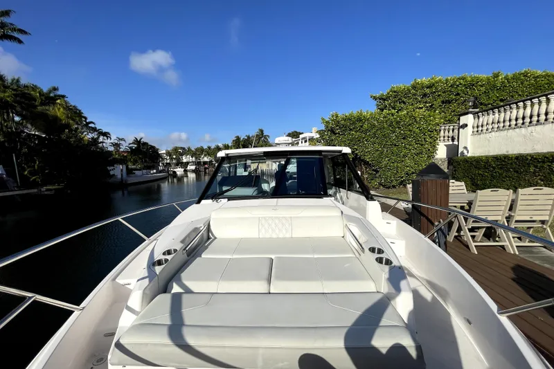 Slide: The Image of 2021 Regal 36 XO yacht with spacious deck, docked by lush greenery. - 39