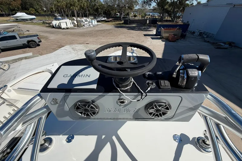 Slide: The Image of 2021 SeaVee 390Z boat helm with Garmin system and controls, docked outdoors. - 29