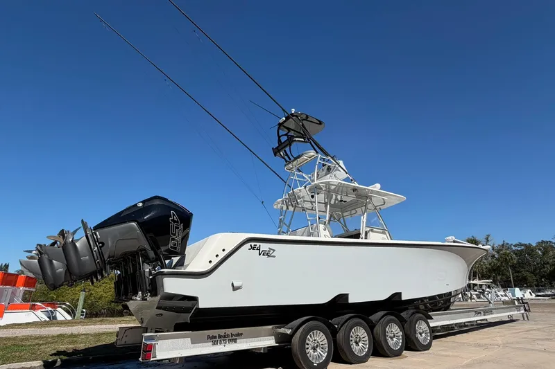 Slide: The Image of 2021 SeaVee 390Z boat on trailer with triple outboard engines under clear blue sky. - 3