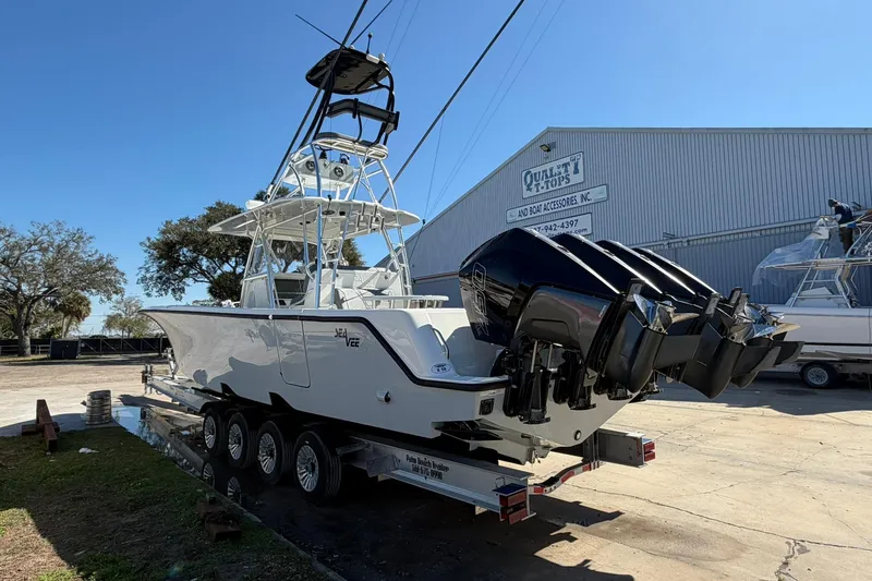 Slide: The Image of 2021 SeaVee 390Z boat on trailer with multiple outboard engines, parked outdoors. - 5