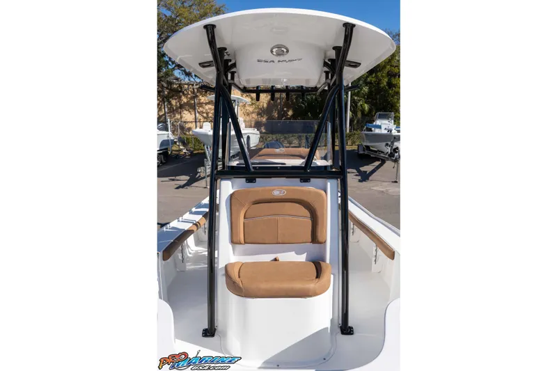 Slide: The Image of 2024 Sea Hunt BX 22 BR boat with tan seating and T-top in a marina setting. - 26