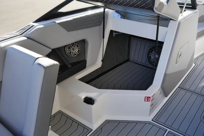Slide: The Image of 2026 Nautique Super Air Nautique S23 interior with storage compartment and speaker system. - 8