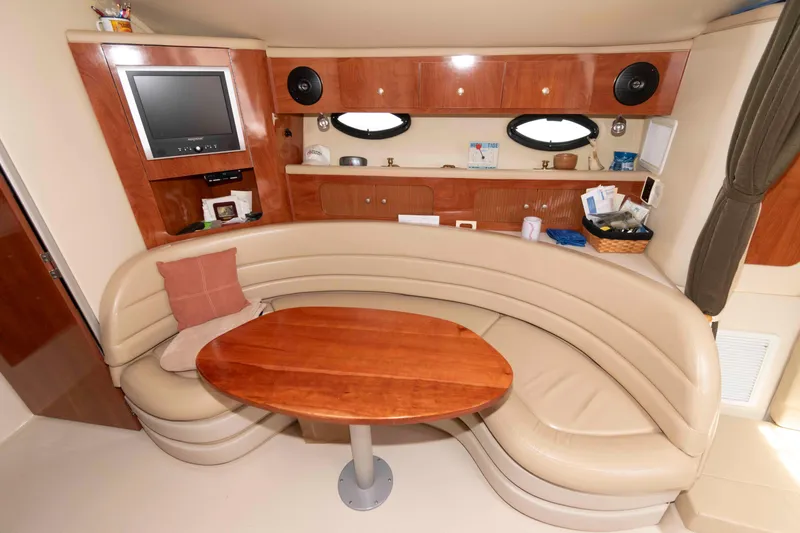 Slide: The Image of Interior of 2007 Larson Cabrio 370 yacht with curved seating and wooden table. - 11