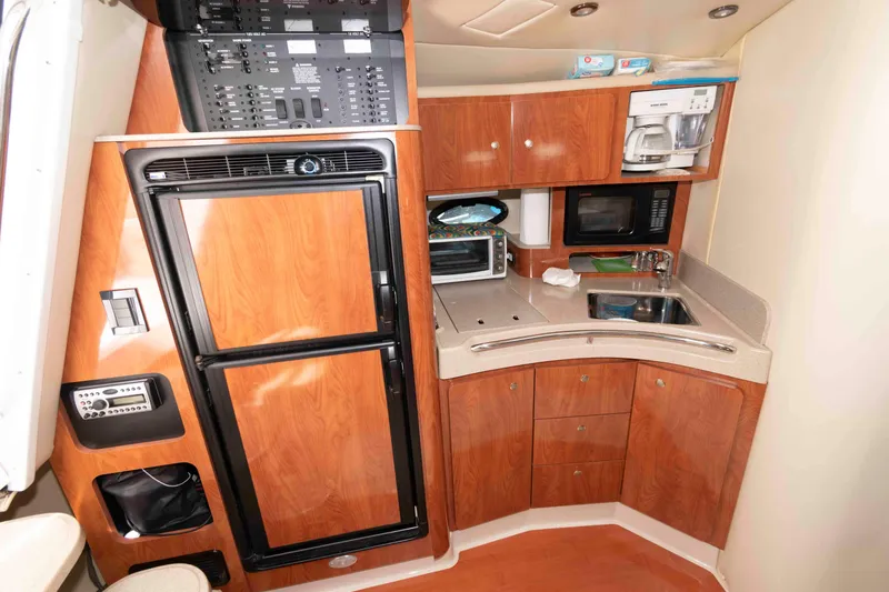 Slide: The Image of 2007 Larson Cabrio 370 yacht kitchen with wood cabinetry, appliances, and compact design. - 12