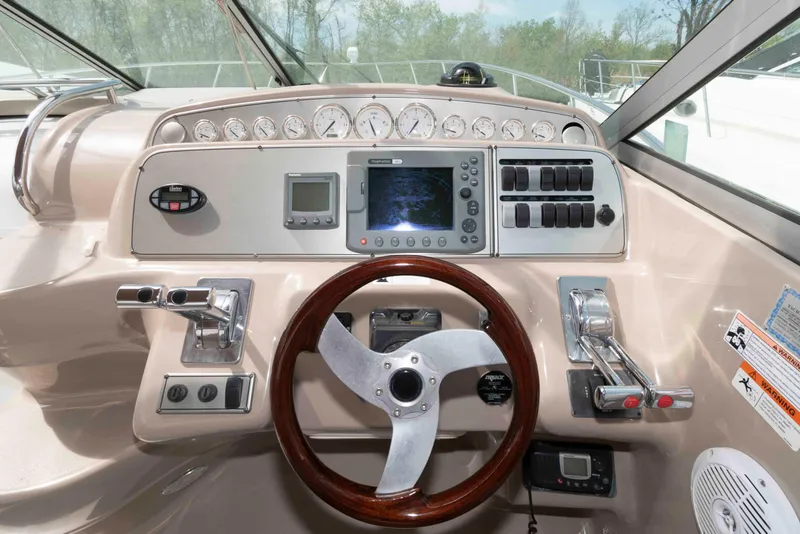 Slide: The Image of 2007 Larson Cabrio 370 helm with steering wheel, gauges, and navigation controls. - 7