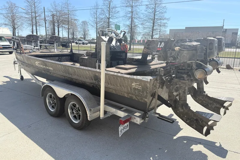 Slide: The Image of 2022 Pro-Drive SBX 2060x boat on trailer, dual motors, parked outdoors. - 4