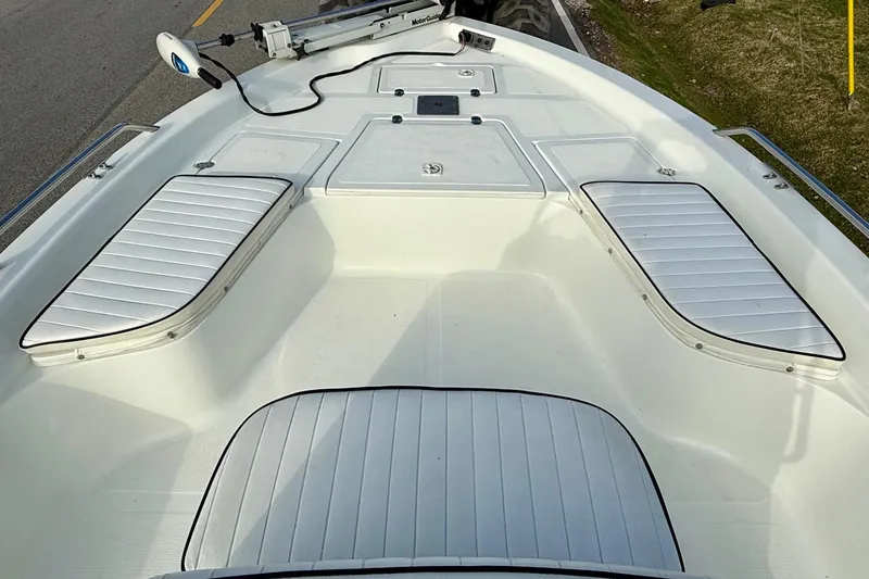 Slide: The Image of 2002 Bay Stealth 2030 boat interior with white cushioned seating and storage compartments. - 12