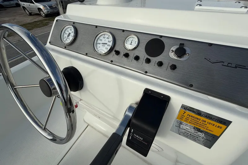 Slide: The Image of Steering console of a 2002 Bay Stealth 2030 boat with gauges and controls. - 15