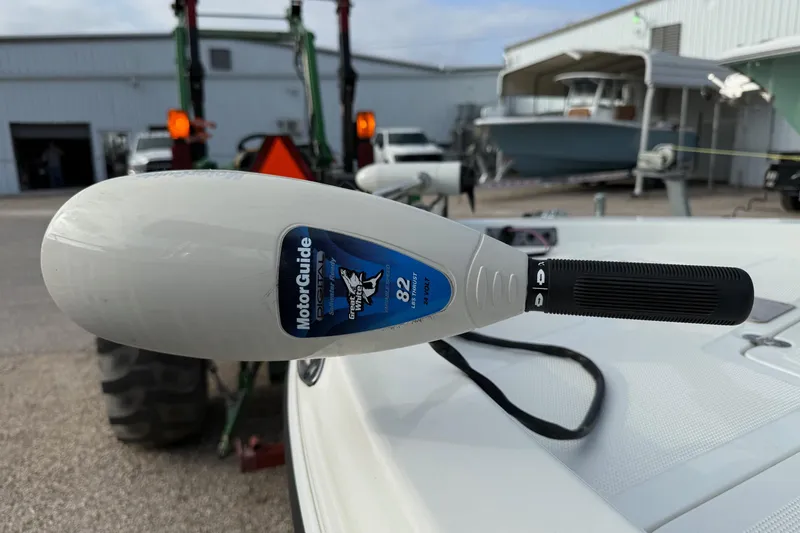 Slide: The Image of MotorGuide trolling motor on 2002 Bay Stealth 2030 boat, parked near a workshop. - 17