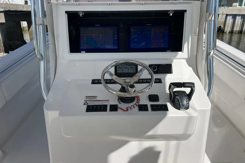 Slide: The Image of 2023 Contender 39 ST boat dashboard with steering wheel and dual displays. - 15