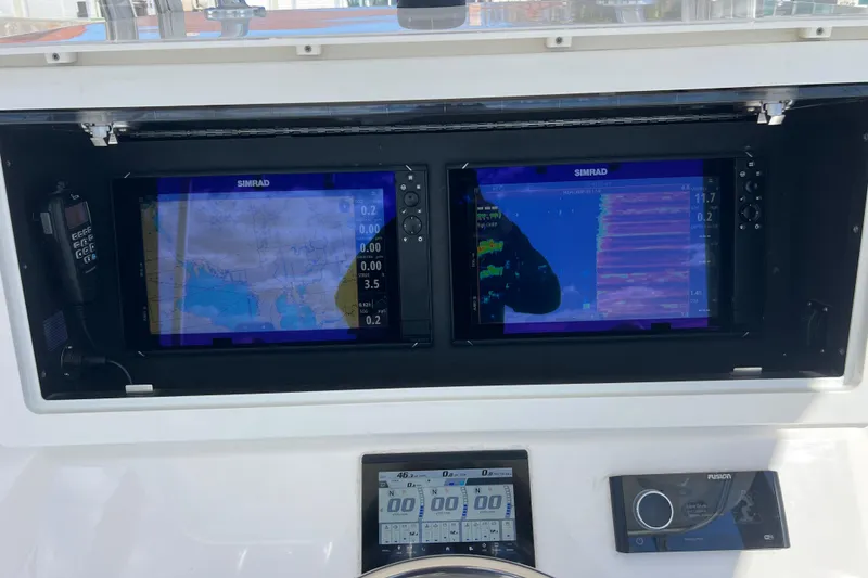 Slide: The Image of 2023 Contender 39 ST boat dashboard with dual Simrad displays and navigation controls. - 16
