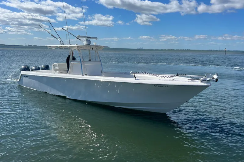 Slide: The Image of 2023 Contender 39 ST boat on calm water under a blue sky. - 2