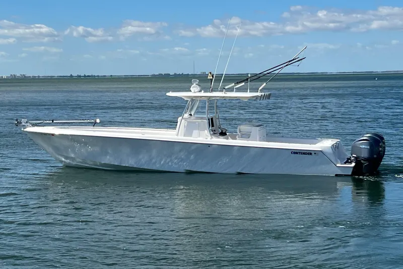 Slide: The Image of 2023 Contender 39 ST boat on calm water under a clear blue sky. - 21