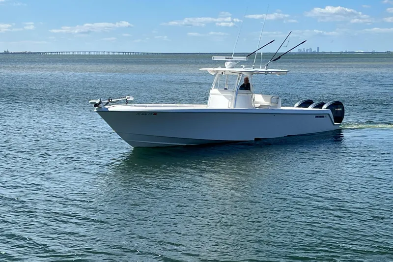 Slide: The Image of 2023 Contender 39 ST boat cruising on calm waters under a clear blue sky. - 22