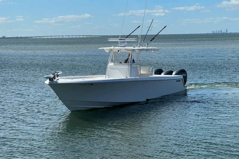 Slide: The Image of 2023 Contender 39 ST boat cruising on calm waters under a clear blue sky. - 23