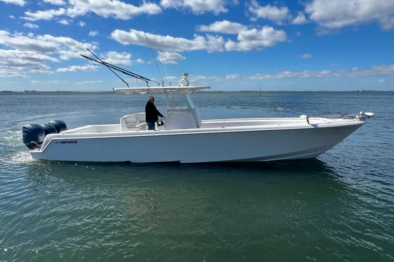 Slide: The Image of 2023 Contender 39 ST boat cruising on calm water under a blue sky. - 25