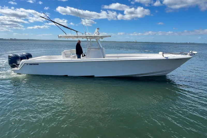 Slide: The Image of 2023 Contender 39 ST boat cruising on calm waters under a clear blue sky. - 26
