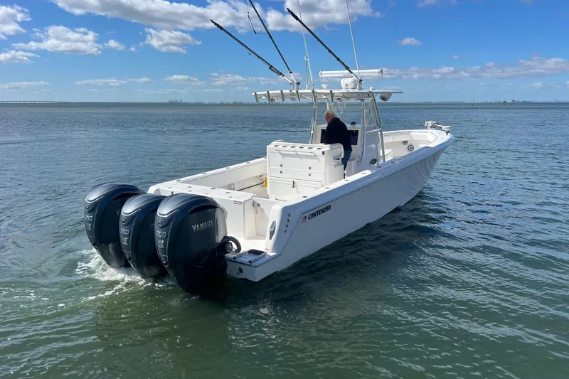 Slide: The Image of 2023 Contender 39 ST boat with triple Yamaha engines on open water. - 27